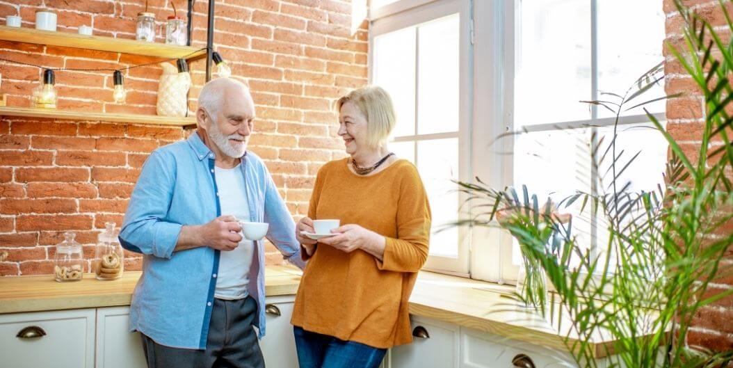 Elderly Couple Shares Coffee in Stylish Kitchen at Independent Living Community