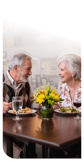 Elderly Couple Sharing a Romantic Dinner With Fresh Flowers in Independent Living