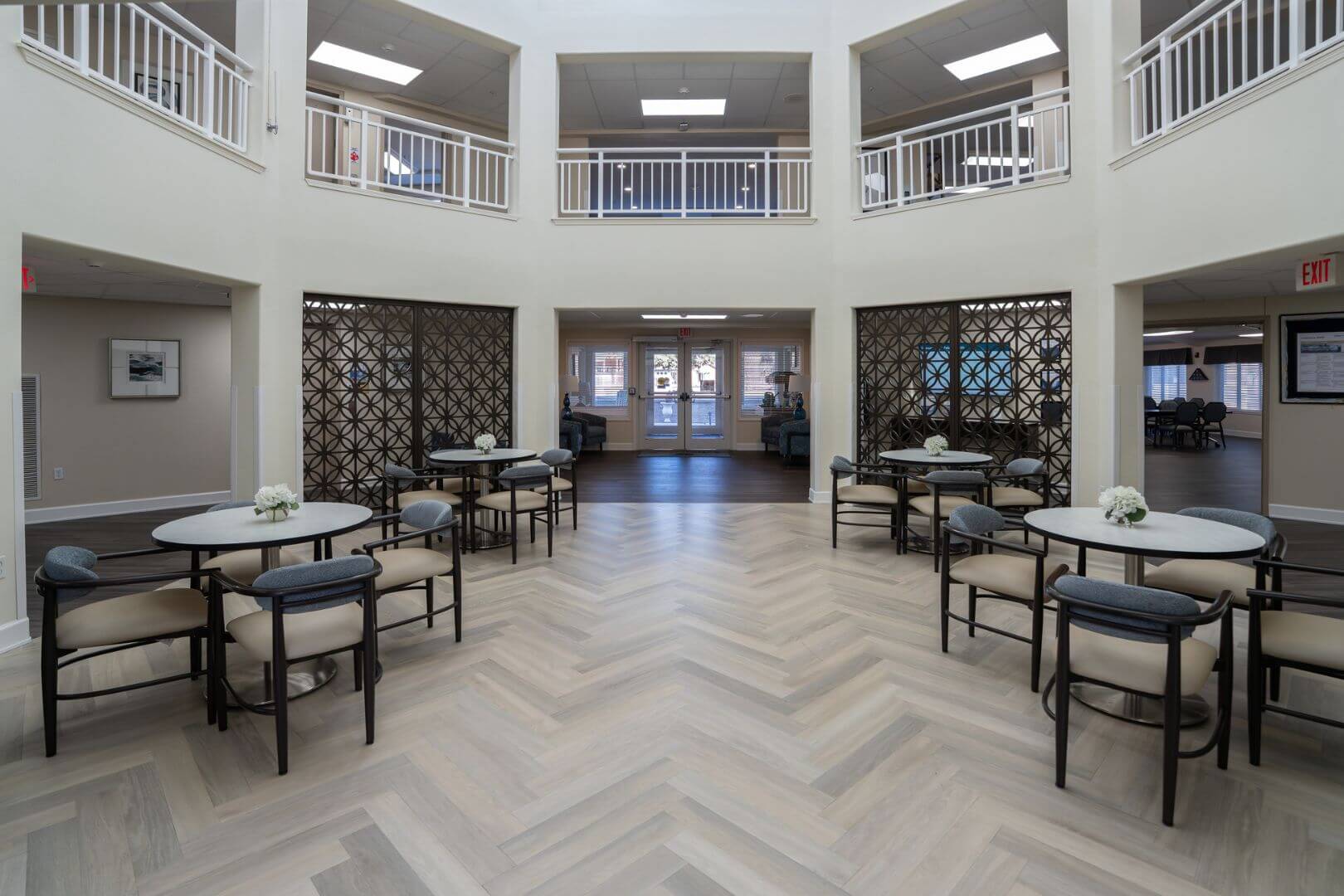Airy Two-Story Common Area with Herringbone Floors and Decorative Screens at an Independent Living Community