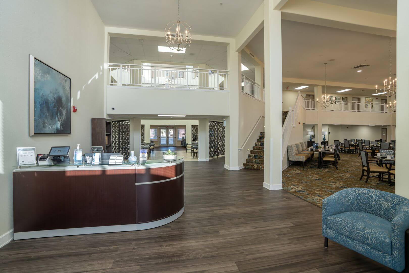 Bright Reception Lobby with Curved Desk and Chandelier at an Independent Living Facility