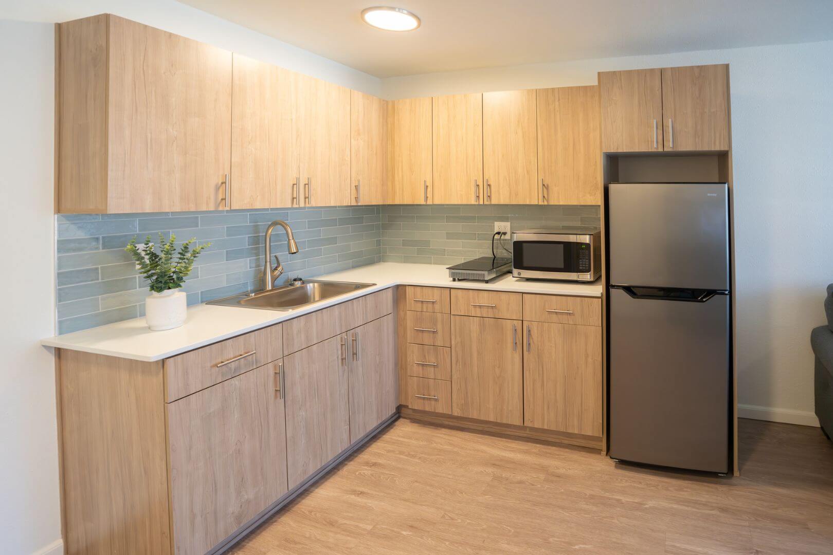 Modern Resident Kitchen with Light Wood Cabinets and Stainless Appliances at an Independent Living Facility