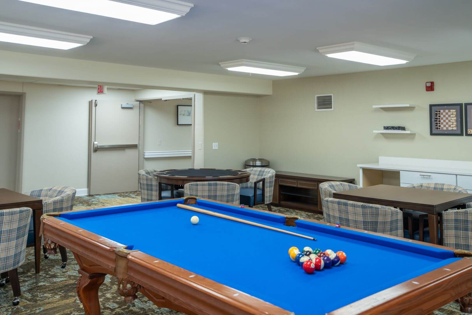 Bright Billiards Room with Blue Pool Table and Card Seating at an Independent Living Facility