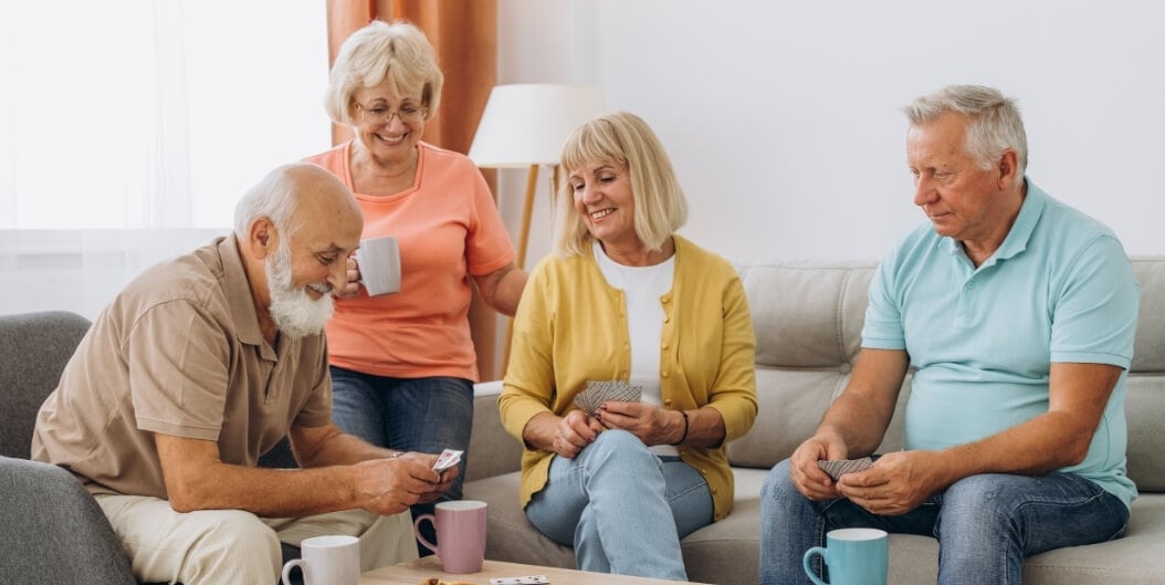 Elderly Friends Playing Cards in Spacious Apartment at Independent Living Facility